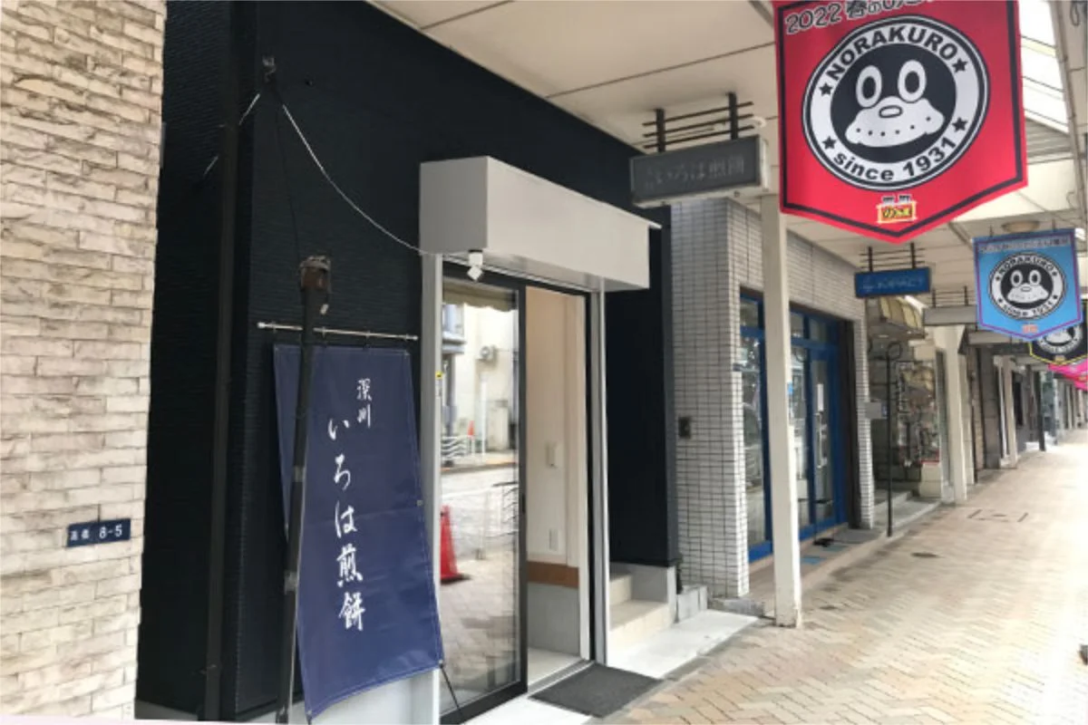 のらくろの旗が並ぶ高橋商店街と、深川いろは煎餅の店先